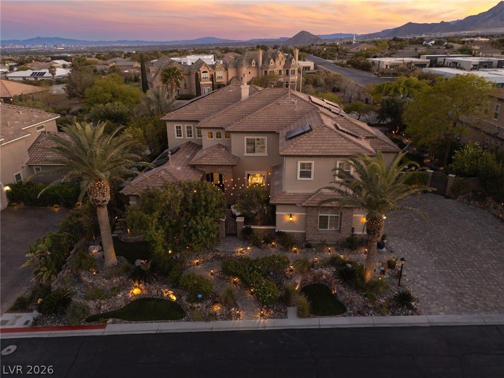 9795 Amador Ranch Avenue, Las Vegas, NV 89149 Sweeping mountain and valley views frame this majestic multi-level estate at twilight.