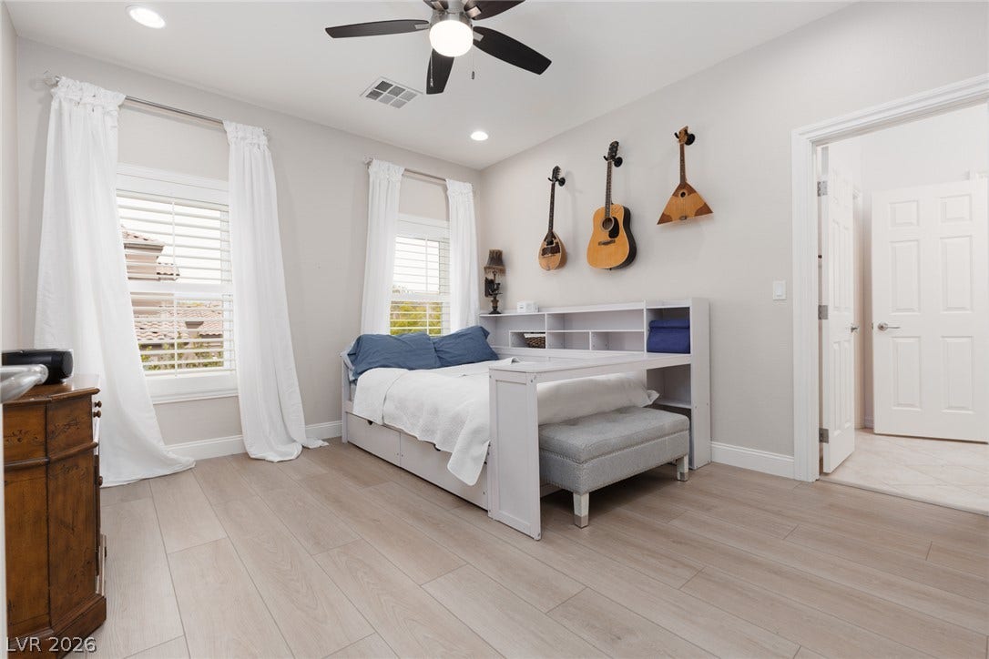 9795 Amador Ranch Avenue, Las Vegas, NV 89149 Hardwood floors and plantation shutters elevate this bright, modern secondary bedroom space.