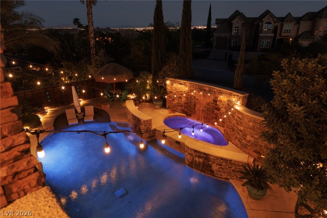 9795 Amador Ranch Avenue, Las Vegas, NV 89149 An illuminated pool and spa offer a resort-style retreat set against glittering city lights.