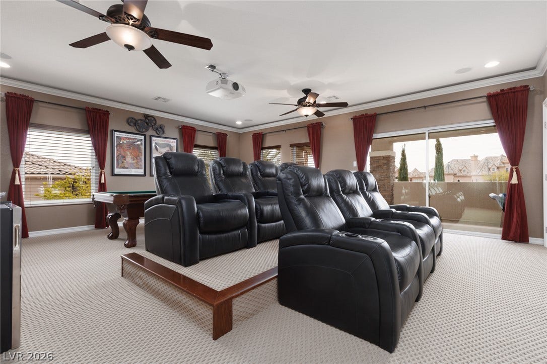 9795 Amador Ranch Avenue, Las Vegas, NV 89149 A spacious home theater features plush carpet and crown molding details.