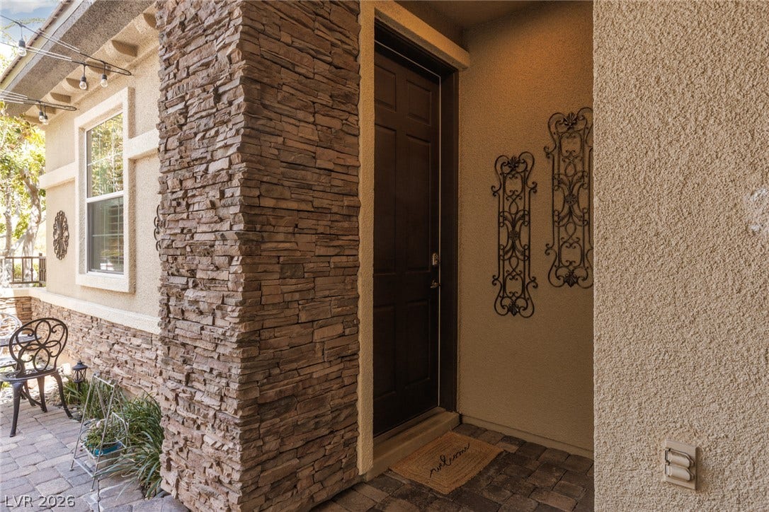 9795 Amador Ranch Avenue, Las Vegas, NV 89149 Stacked stone accents frame a welcoming recessed entryway with textured stucco walls.