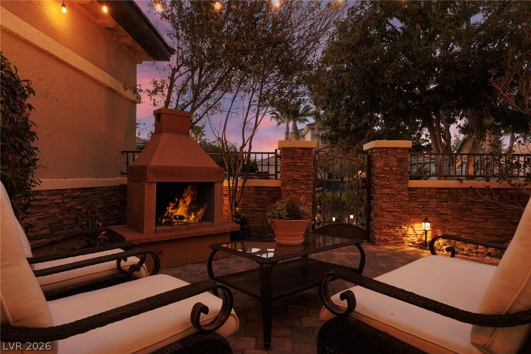 9795 Amador Ranch Avenue, Las Vegas, NV 89149 Stone walls and a wood-burning fireplace create an inviting atmosphere in this private courtyard.