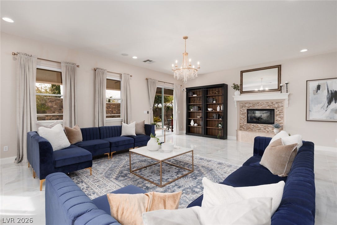 9795 Amador Ranch Avenue, Las Vegas, NV 89149 Gleaming tile floors and a fireplace with stone surround anchor this bright living space.