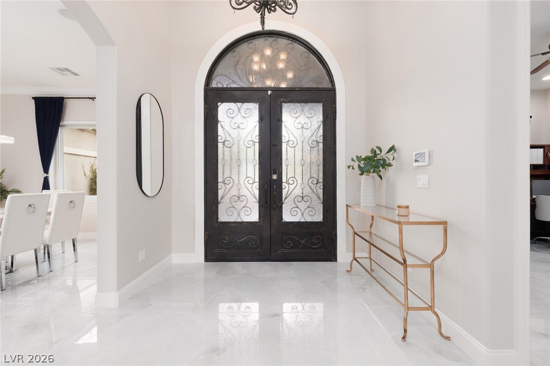 9795 Amador Ranch Avenue, Las Vegas, NV 89149 Polished tile flooring and an arched glass entryway welcome guests into this light-filled home.
