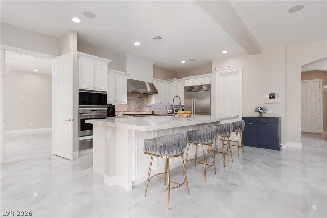 9795 Amador Ranch Avenue, Las Vegas, NV 89149 Polished tile flooring and an expansive stone island anchor this modern culinary space.