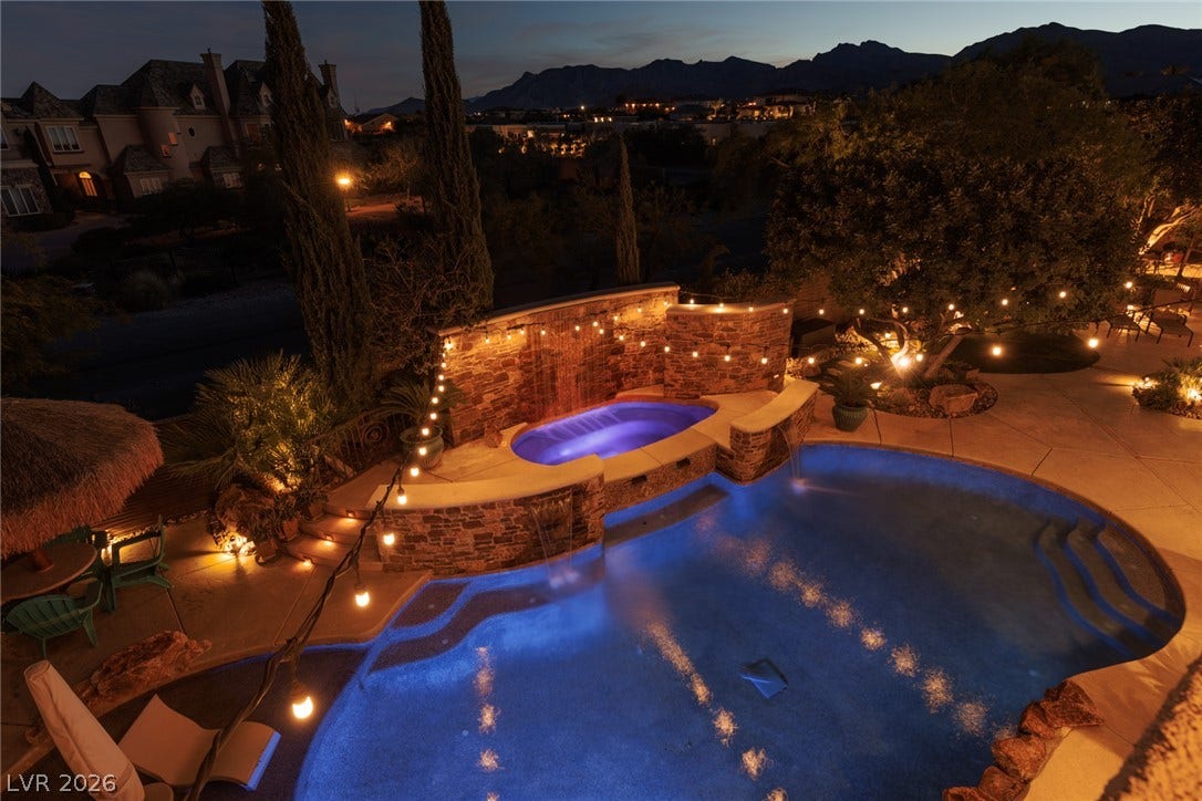 9795 Amador Ranch Avenue, Las Vegas, NV 89149 Dramatic mountain vistas frame the custom backyard oasis featuring a pool and raised spa.