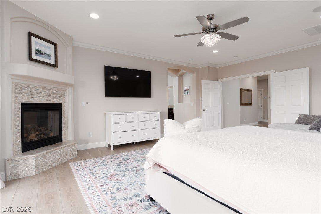 9795 Amador Ranch Avenue, Las Vegas, NV 89149 An inviting corner fireplace and polished wood floors anchor this comfortable bedroom retreat.