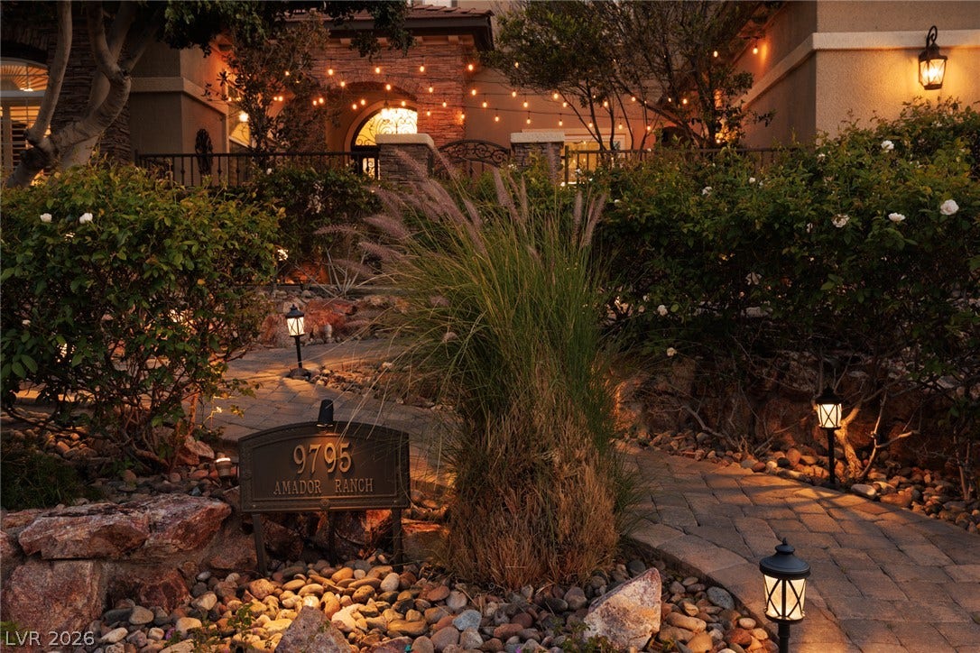9795 Amador Ranch Avenue, Las Vegas, NV 89149 Inviting stone walkways and warm outdoor lighting create a welcoming approach to this elegant home.