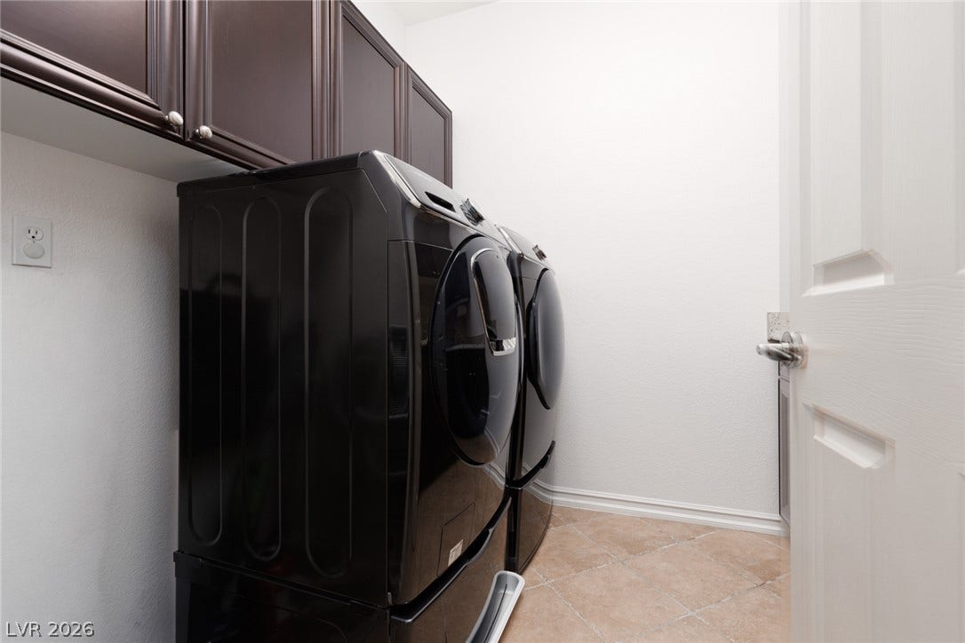 9795 Amador Ranch Avenue, Las Vegas, NV 89149 A functional laundry area features rich dark cabinetry and durable tile flooring.