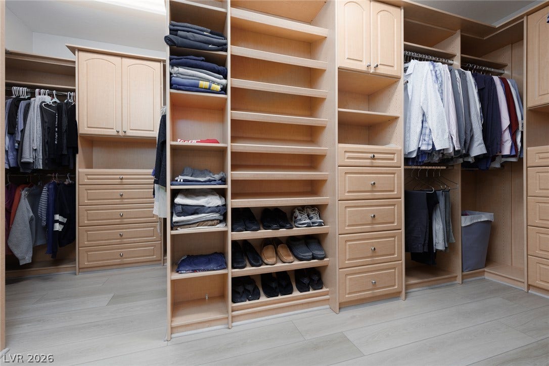 9795 Amador Ranch Avenue, Las Vegas, NV 89149 A spacious custom closet system features extensive wood shelving, drawers, and light wood flooring.