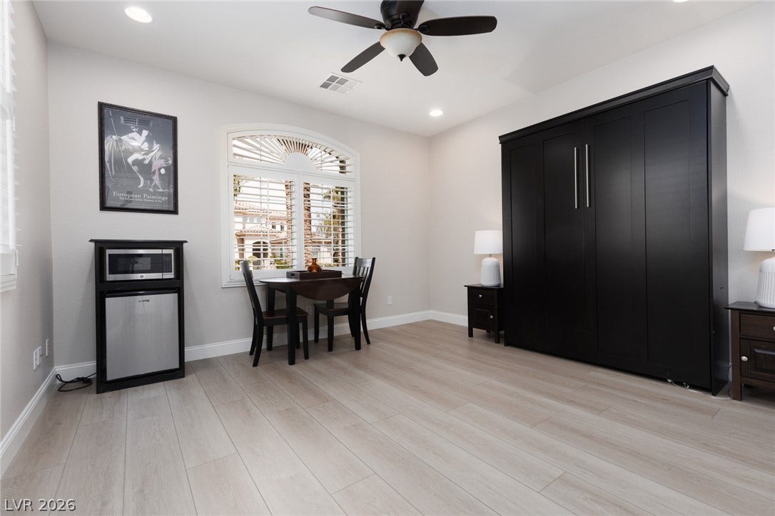 9795 Amador Ranch Avenue, Las Vegas, NV 89149 An arched window and wood-look flooring define this versatile room with recessed lighting.
