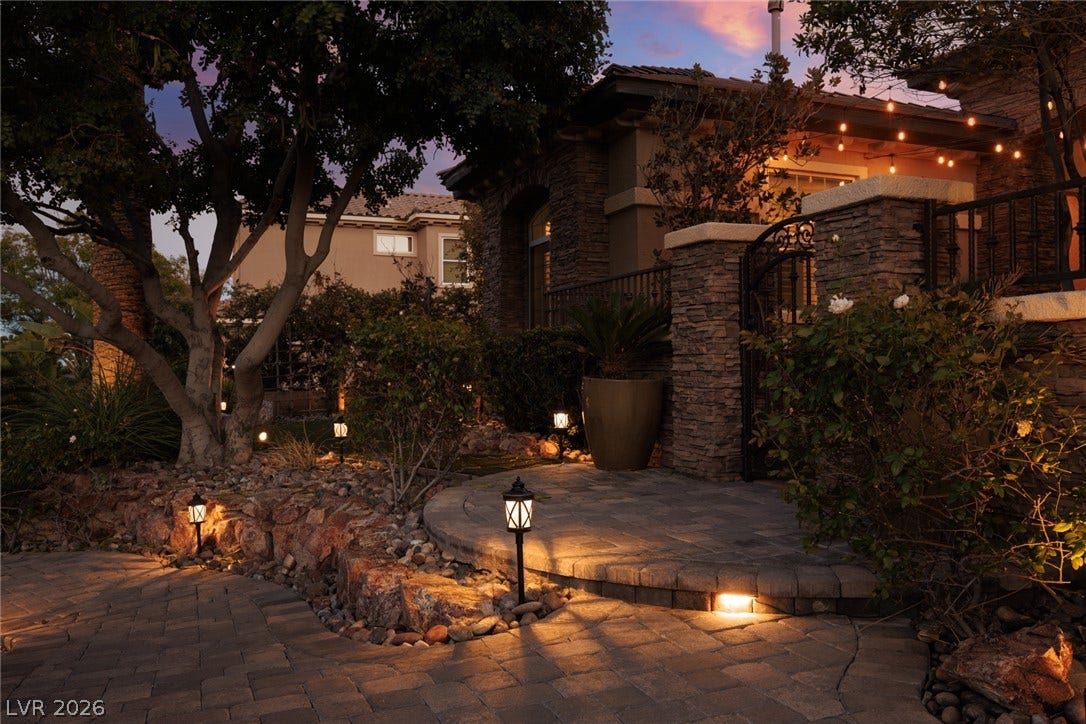 9795 Amador Ranch Avenue, Las Vegas, NV 89149 Artfully designed stone pathways and architectural lighting create a warm evening welcome.