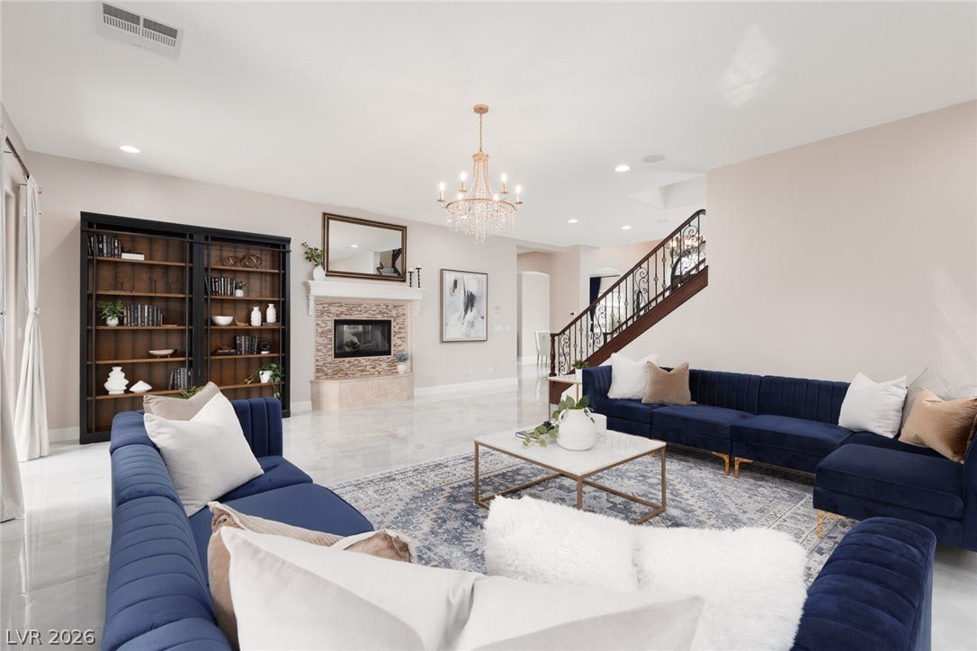 9795 Amador Ranch Avenue, Las Vegas, NV 89149 Gleaming tile floors and a fireplace with a decorative mantel define this open living space.