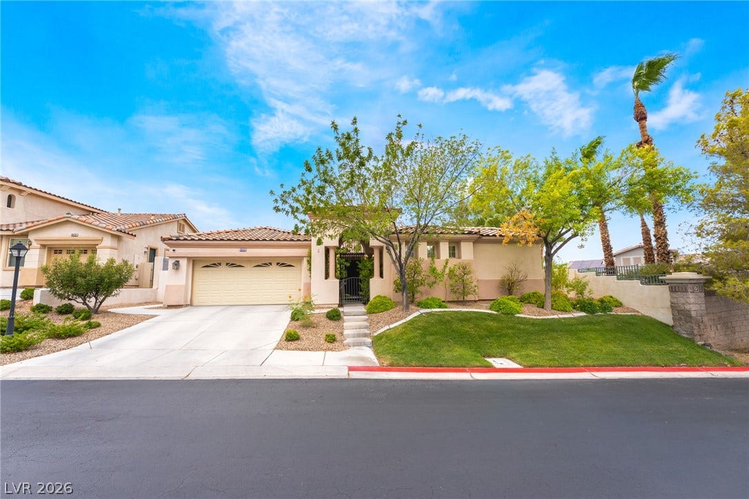 3033 Via Meridiana, Henderson, NV 89052 Stately stucco exterior with a classic tile roof showcases neat landscaping and an inviting entry.