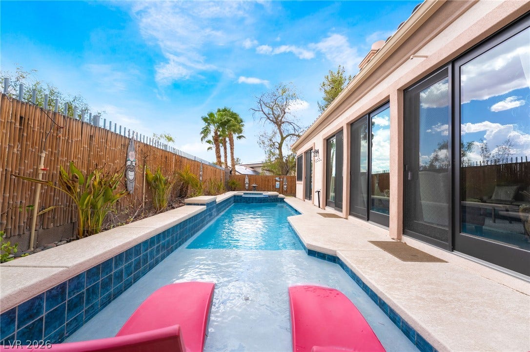 3033 Via Meridiana, Henderson, NV 89052 A sparkling lap pool runs alongside the home, lined by wide sliding glass doors.