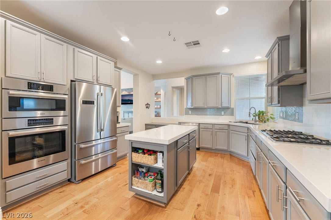 3033 Via Meridiana, Henderson, NV 89052 Gleaming hardwood floors complement sleek stone countertops and stainless appliances in this modern kitchen.