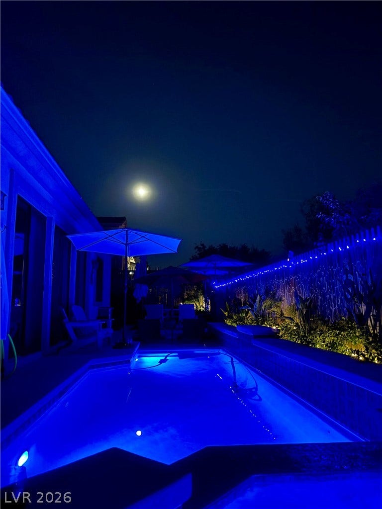 3033 Via Meridiana, Henderson, NV 89052 An inviting swimming pool glows beneath the night sky in this private outdoor oasis.
