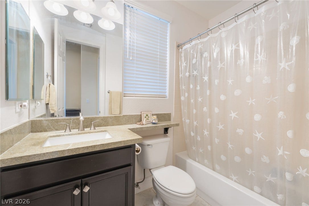 3033 Via Meridiana, Henderson, NV 89052 Polished stone counters and clean tile floors elevate this classic full bathroom.