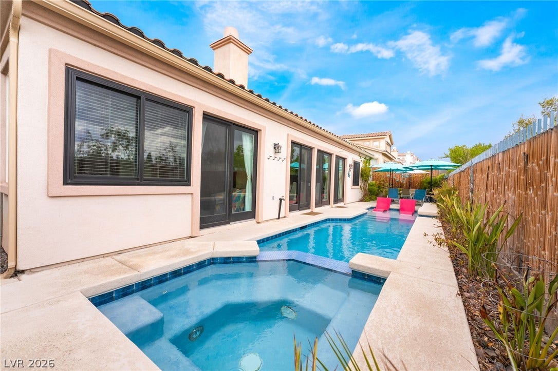 3033 Via Meridiana, Henderson, NV 89052 A sparkling lap pool and integrated spa sit adjacent to the stucco exterior.