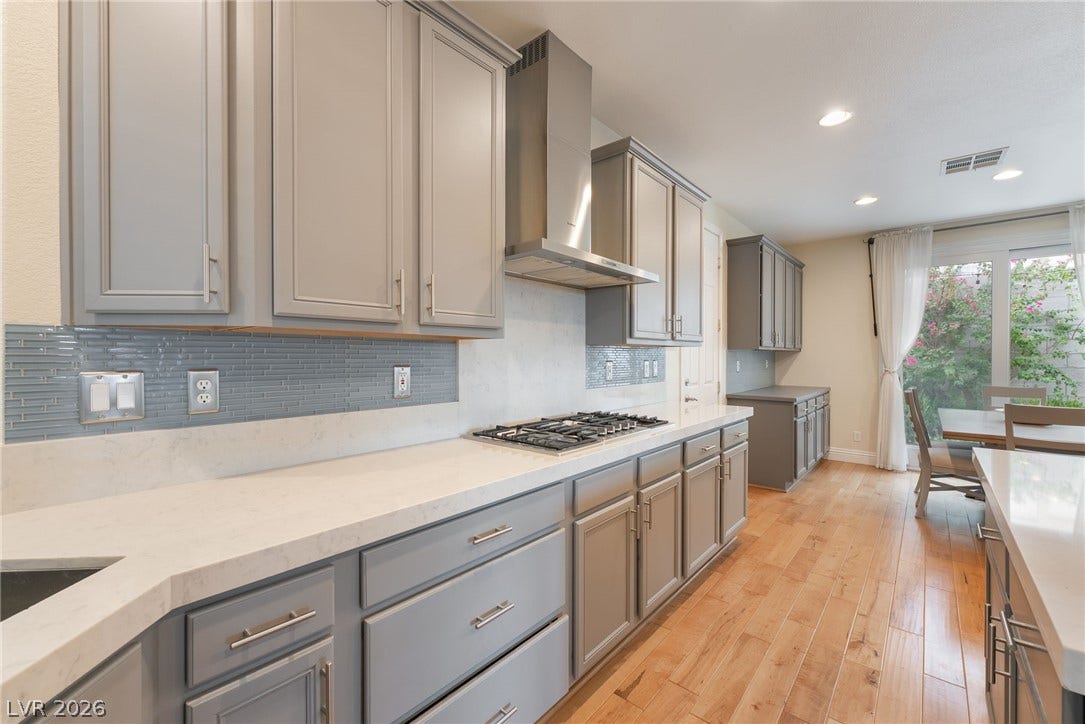 3033 Via Meridiana, Henderson, NV 89052 Gleaming hardwood floors and stone countertops anchor this modern kitchen with ample cabinetry.