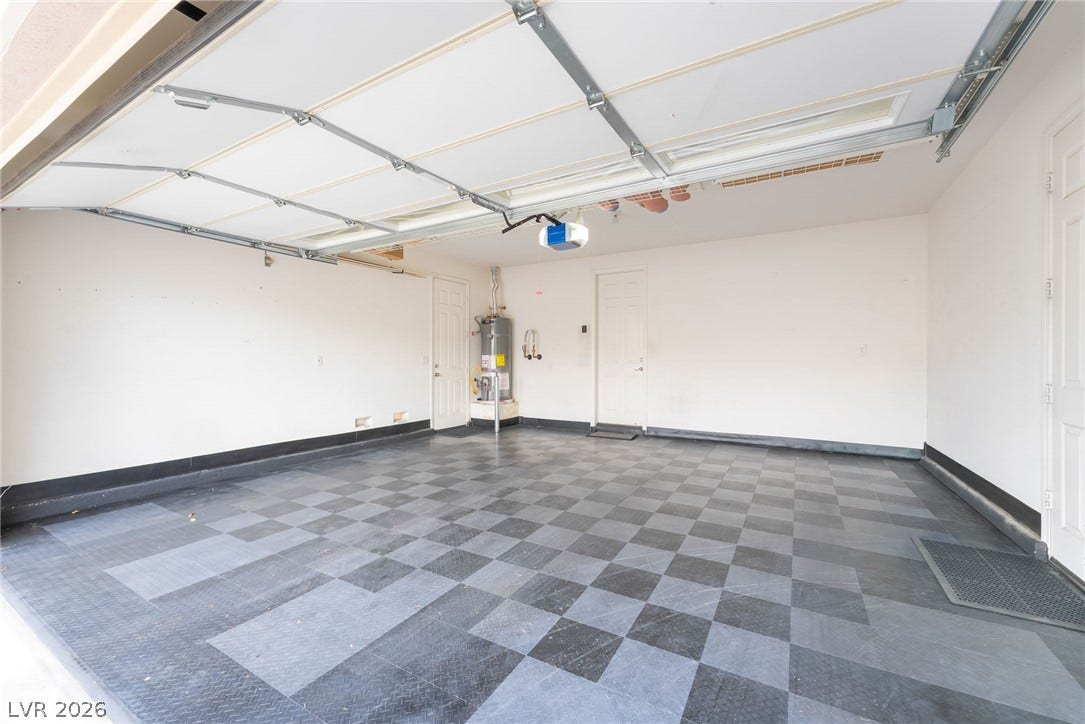 3033 Via Meridiana, Henderson, NV 89052 Checkerboard pattern flooring highlights this spacious garage featuring dual interior access doors.