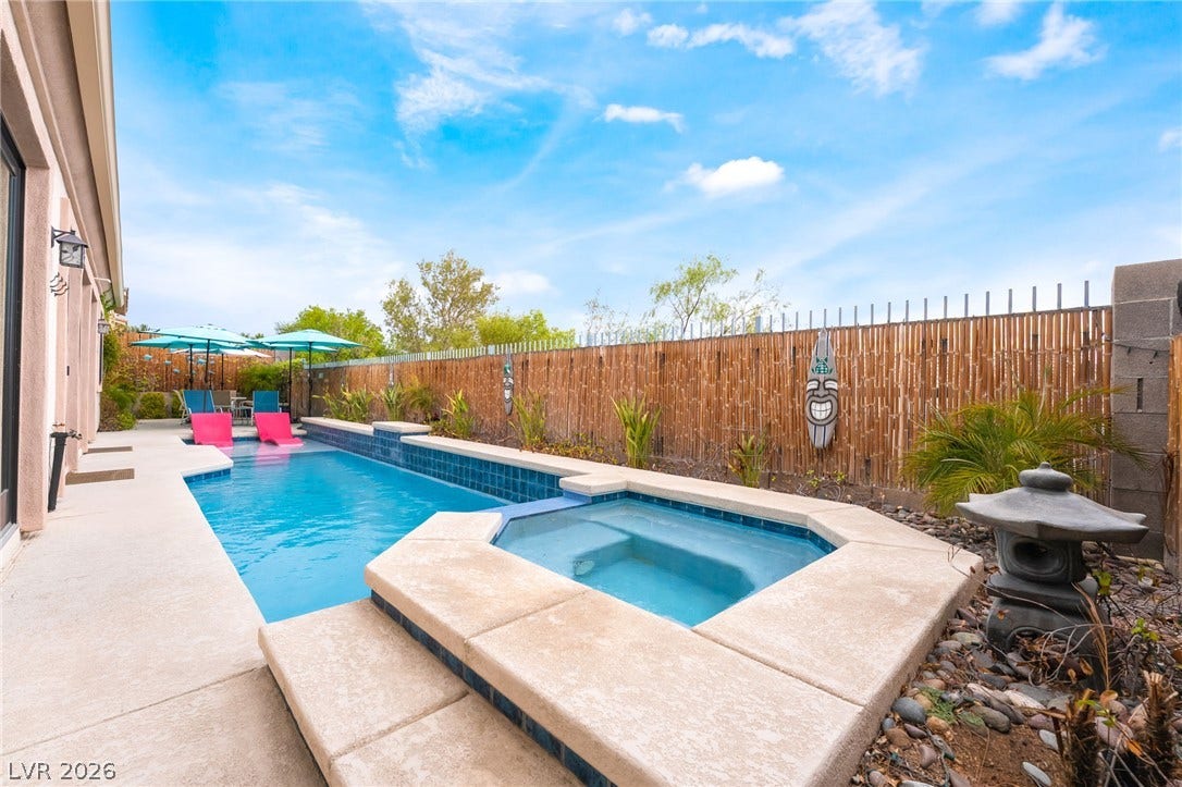 3033 Via Meridiana, Henderson, NV 89052 An inviting swimming pool and integrated spa sit surrounded by a concrete patio and privacy fencing.