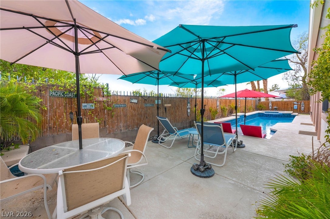 3033 Via Meridiana, Henderson, NV 89052 A spacious concrete patio borders an inviting in-ground pool under sunny skies.