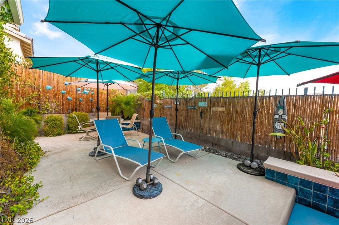 3033 Via Meridiana, Henderson, NV 89052 Concrete hardscaping and bamboo fencing define this private outdoor lounge area.