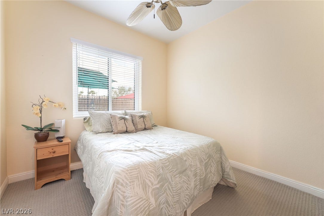 3033 Via Meridiana, Henderson, NV 89052 A quiet bedroom showcases neutral walls and a window overlooking the outdoors.