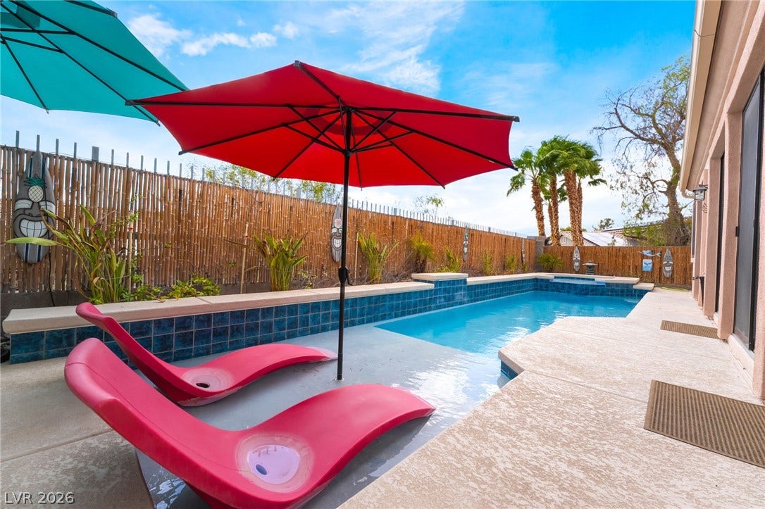 3033 Via Meridiana, Henderson, NV 89052 An inviting lap pool sits alongside textured concrete decking under wide desert skies.