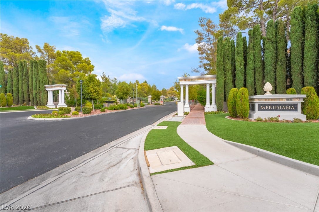 3033 Via Meridiana, Henderson, NV 89052 Stately pillars and manicured greenery frame a welcoming entrance with pristine sidewalks and curbing.