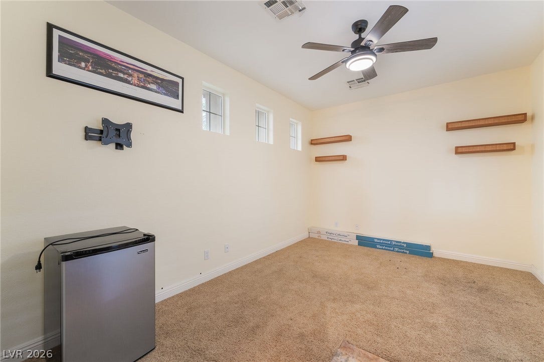 3033 Via Meridiana, Henderson, NV 89052 Natural light streams through high transom windows into this versatile room with plush carpeting.