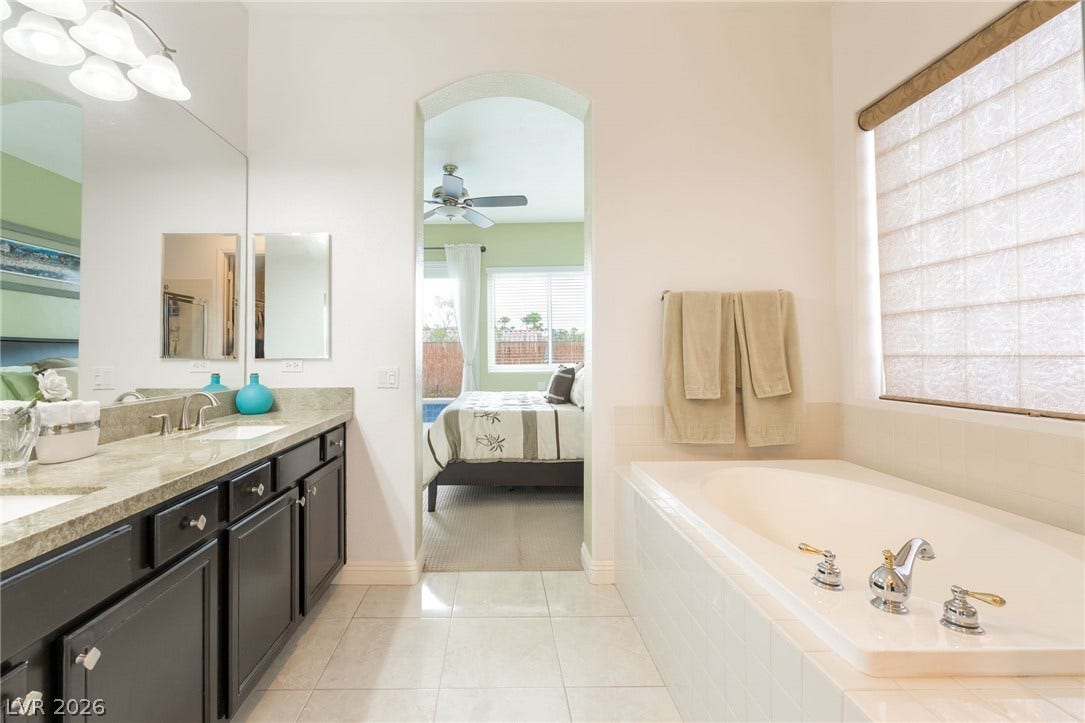 3033 Via Meridiana, Henderson, NV 89052 An arched doorway connects the dual-vanity washroom to the adjacent suite.
