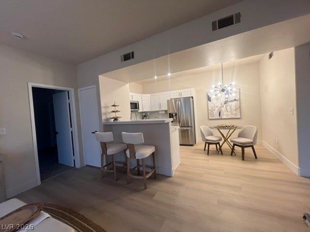 2131 Hussium Hills Street, #208, Las Vegas, NV 89108 Gleaming hardwood floors and a modern breakfast bar anchor this open-concept living and dining layout.