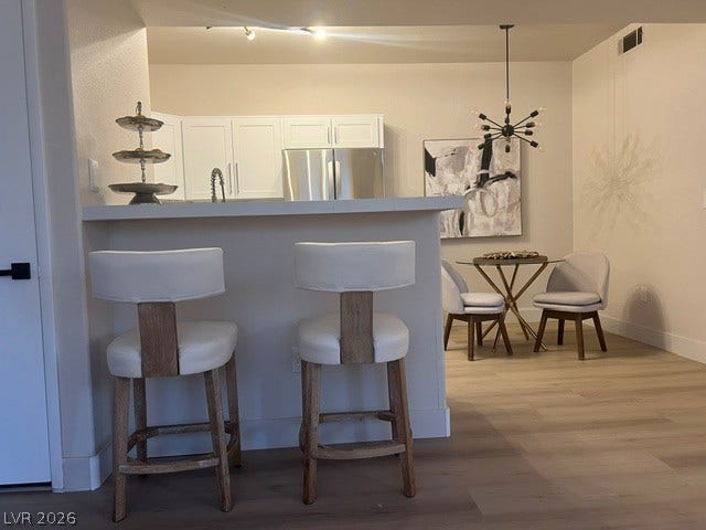 2131 Hussium Hills Street, #208, Las Vegas, NV 89108 A breakfast bar overlooks the modern kitchen with clean lines and handsome hardwood flooring.