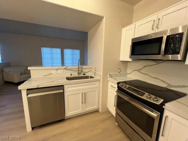 2131 Hussium Hills Street, #208, Las Vegas, NV 89108 Elegant stone countertops and modern stainless steel appliances define this functional kitchen space.