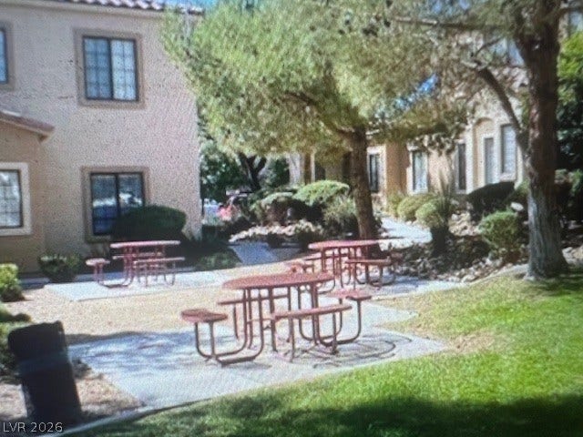 2131 Hussium Hills Street, #208, Las Vegas, NV 89108 Mature trees shade a shared outdoor common area featuring multiple picnic benches.