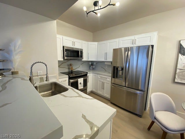 2131 Hussium Hills Street, #208, Las Vegas, NV 89108 Crisp white cabinetry pairs with quartz countertops and stainless steel appliances in this kitchen.
