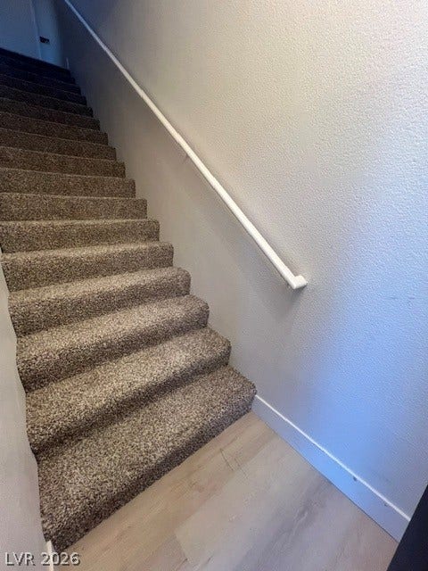 2131 Hussium Hills Street, #208, Las Vegas, NV 89108 Plush carpeted stairs ascend alongside smooth neutral walls accented by crisp white trim.