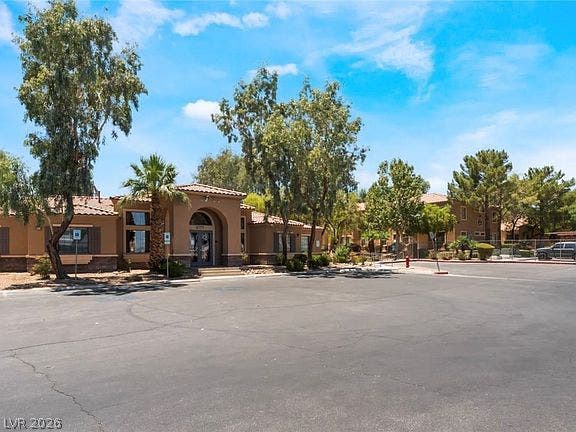 2131 Hussium Hills Street, #208, Las Vegas, NV 89108 Mature trees frame the stucco exterior and tiled roofline of this welcoming clubhouse entry.