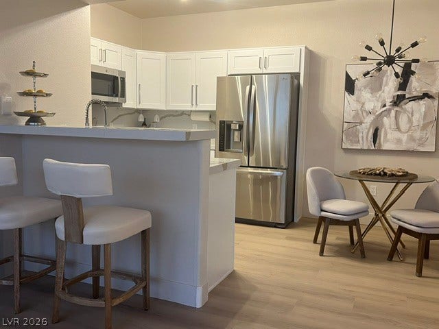 2131 Hussium Hills Street, #208, Las Vegas, NV 89108 Sleek modern cabinetry, quartz counters, and light wood floors define this open kitchen design.
