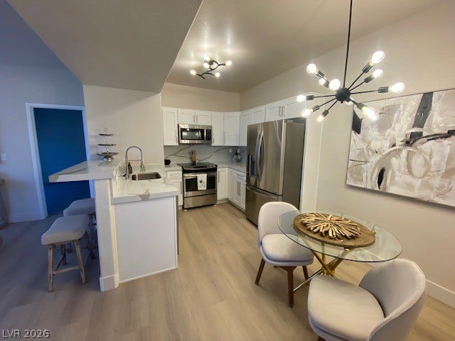 2131 Hussium Hills Street, #208, Las Vegas, NV 89108 Streamlined cabinetry and modern appliances define this efficient culinary space with seamless wood flooring.