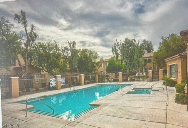 2131 Hussium Hills Street, #208, Las Vegas, NV 89108 A sparkling community pool and spa await under a dramatic, cloud-filled sky.