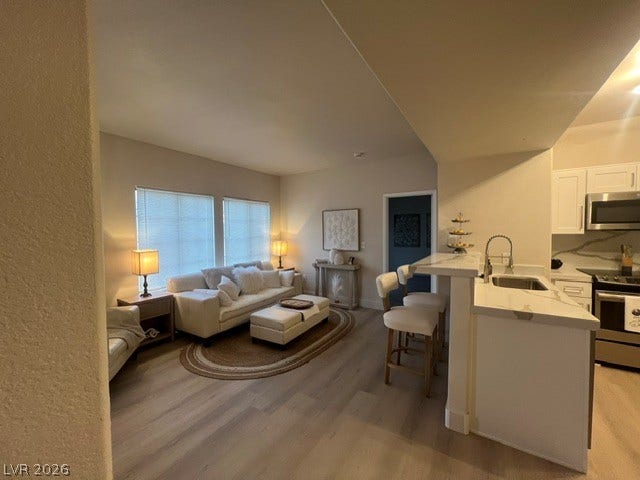 2131 Hussium Hills Street, #208, Las Vegas, NV 89108 An open floor plan seamlessly connects the kitchen bar to a comfortable living area.