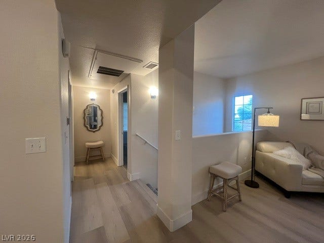 2131 Hussium Hills Street, #208, Las Vegas, NV 89108 Smooth wood floors flow through this light-filled hallway leading to a versatile upper-level landing.