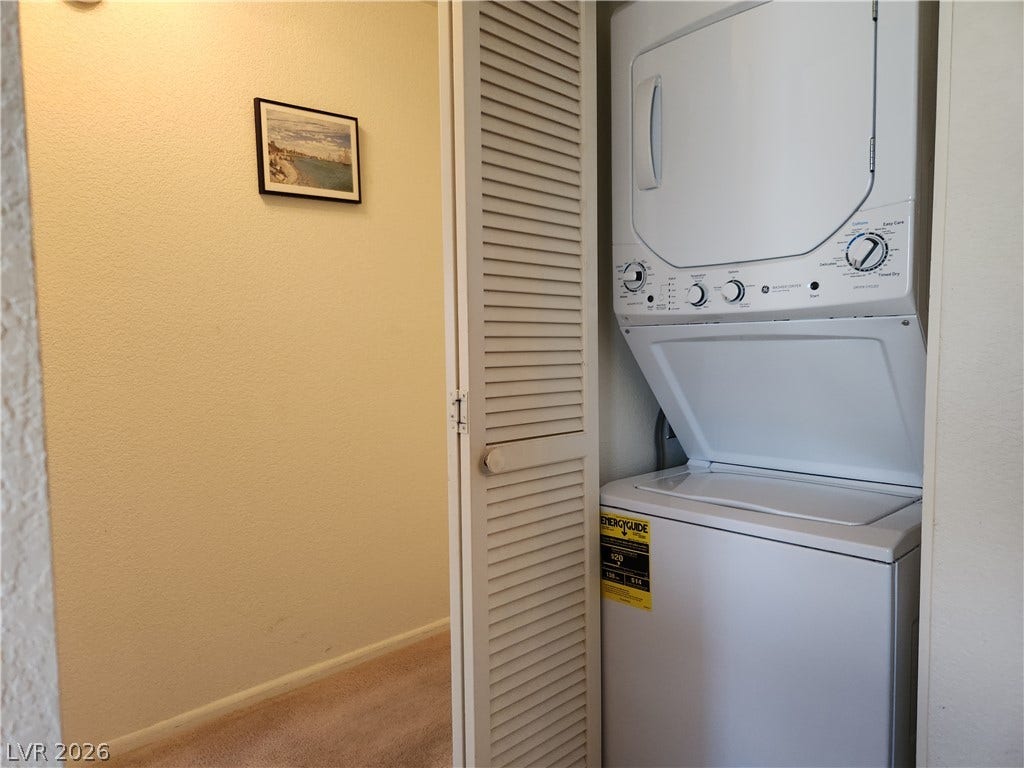 2016 Mesquite Lane, #303, Laughlin, NV 89029 Louvered doors conceal a stackable laundry setup positioned just off a carpeted hallway.