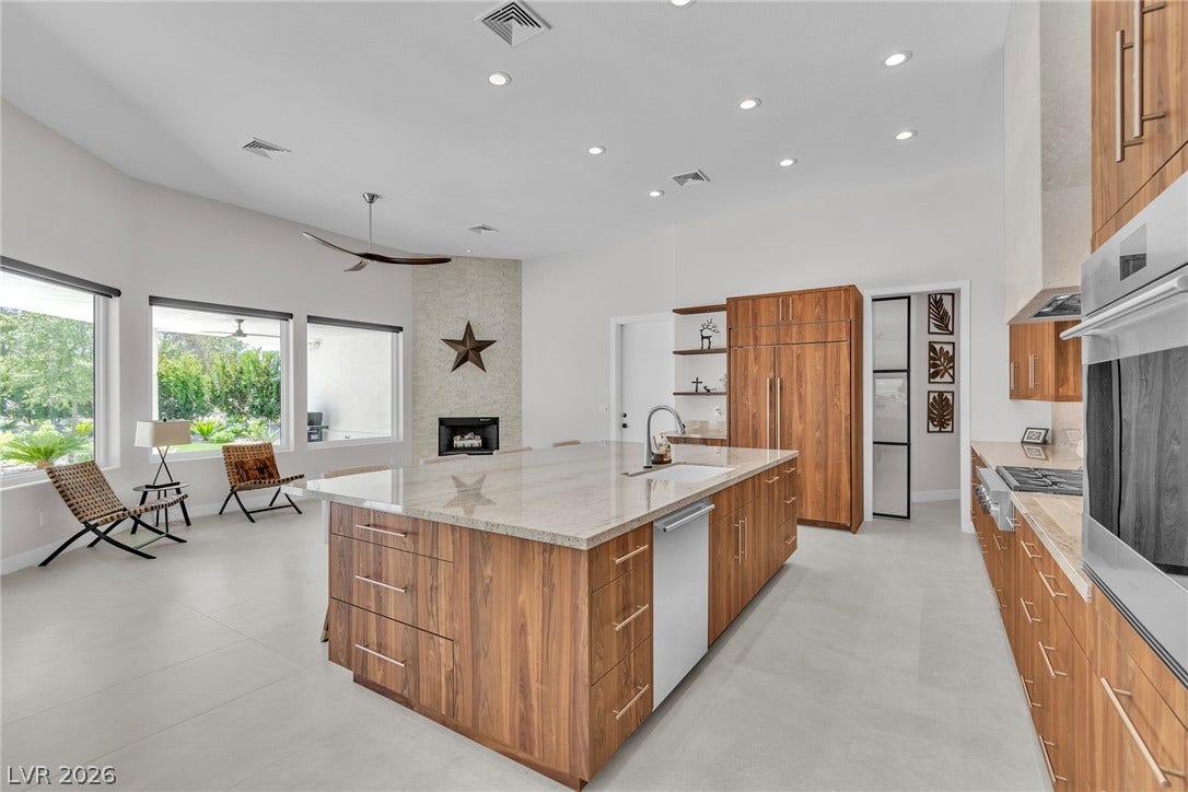 1508 Ten Palms Court, Las Vegas, NV 89117 Rich wood cabinetry and a massive stone island anchor this open-concept culinary space.