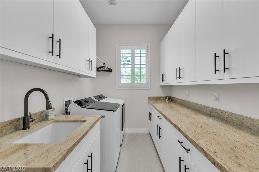 1508 Ten Palms Court, Las Vegas, NV 89117 Stone countertops and ample cabinetry define this functional laundry space with tiled flooring.