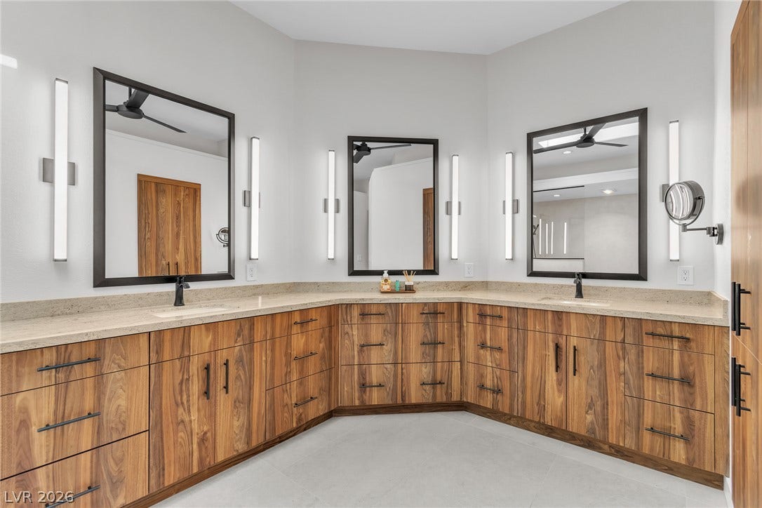 1508 Ten Palms Court, Las Vegas, NV 89117 Rich wood cabinetry and stone countertops anchor this spacious modern washroom.