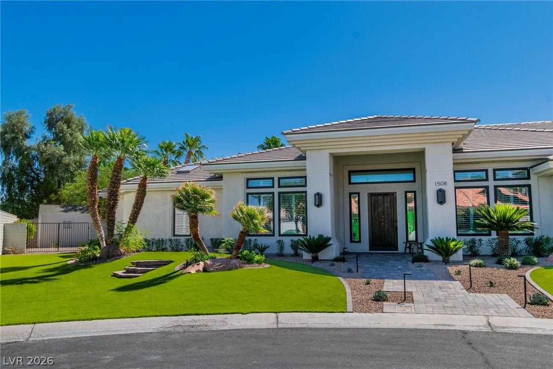 1508 Ten Palms Court, Las Vegas, NV 89117 Manicured landscaping and a paved walkway lead to a grand, covered front entrance.